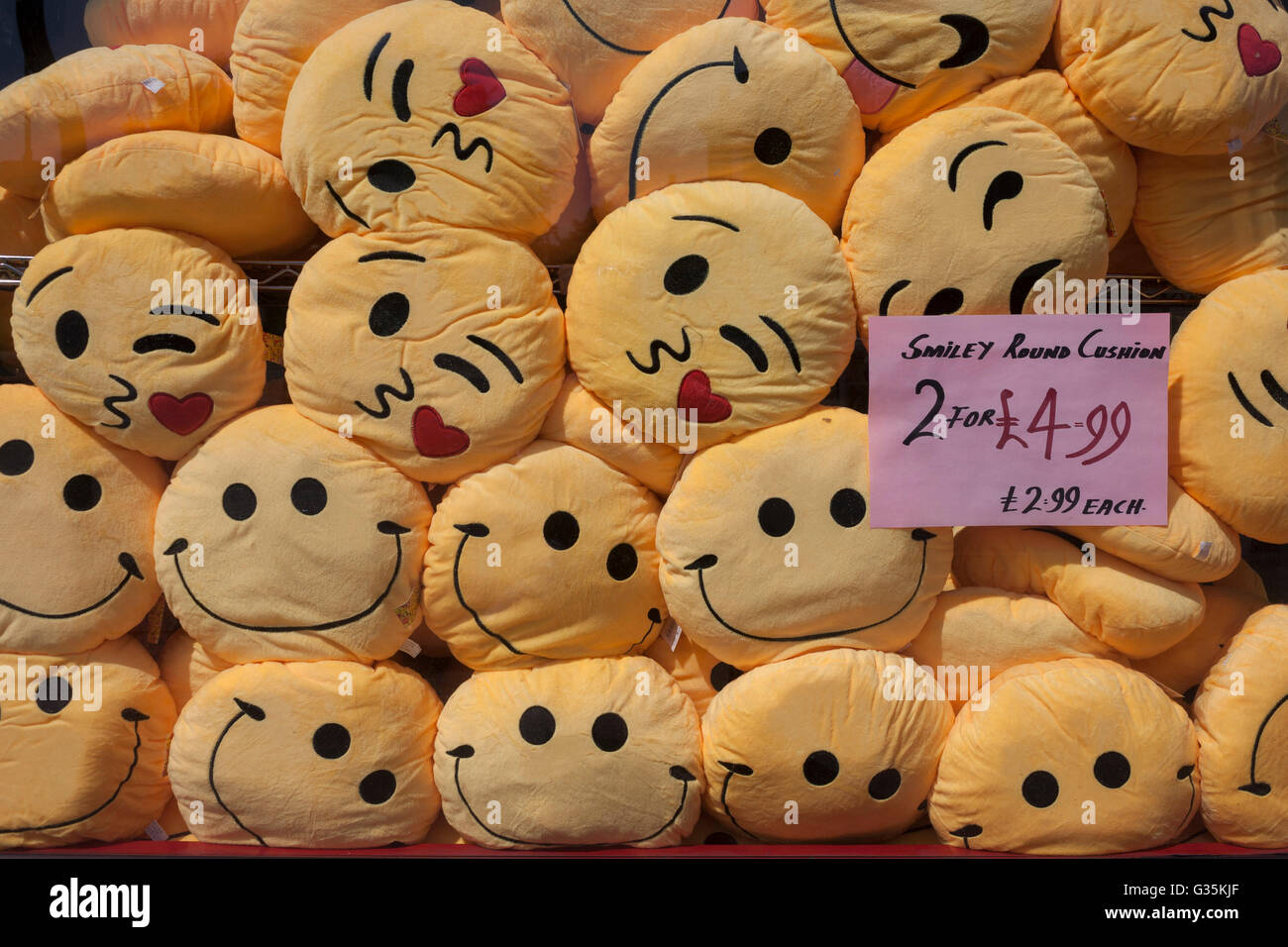 Des tas de coussins smiley entassés dans la fenêtre d'une boutique à Brixton, South London Borough of Lambeth, Angleterre. Banque D'Images Des tas de coussins smiley entassés dans la fenêtre d'une boutique à Brixton, South London Borough of Lambeth, Angleterre. Banque D'Images