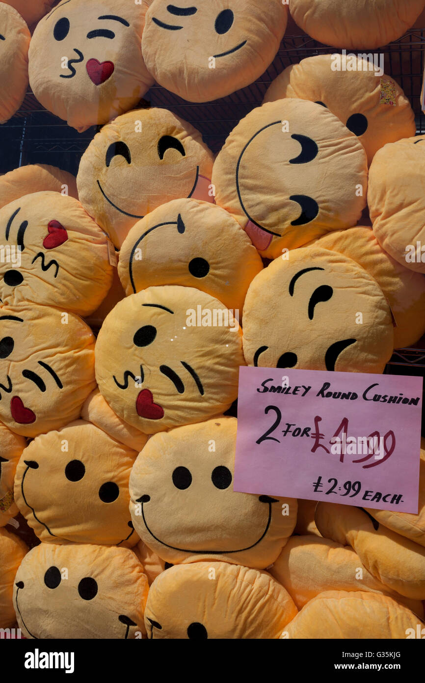 Des tas de coussins smiley entassés dans la fenêtre d'une boutique à Brixton, South London Borough of Lambeth, Angleterre. Banque D'Images Des tas de coussins smiley entassés dans la fenêtre d'une boutique à Brixton, South London Borough of Lambeth, Angleterre. Banque D'Images