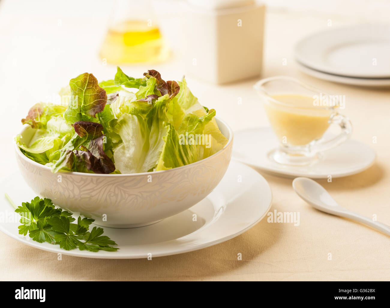 Un saladier sur une table avec de l'huile d'olive et d'une vinaigrette à la moutarde Banque D'Images