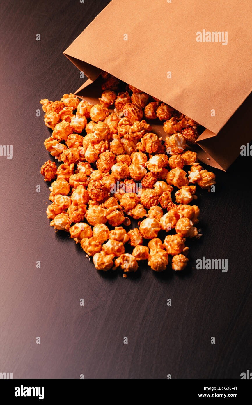 Beaucoup de pop-corn dans un sac en papier sur un fond sombre Banque D'Images