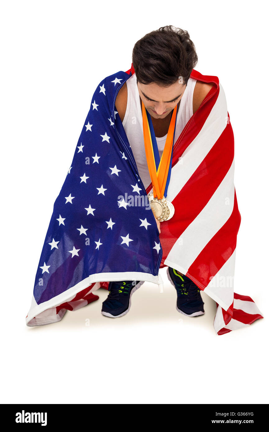 Athlète avec médailles d'autour de son cou enveloppé dans le drapeau américain Banque D'Images
