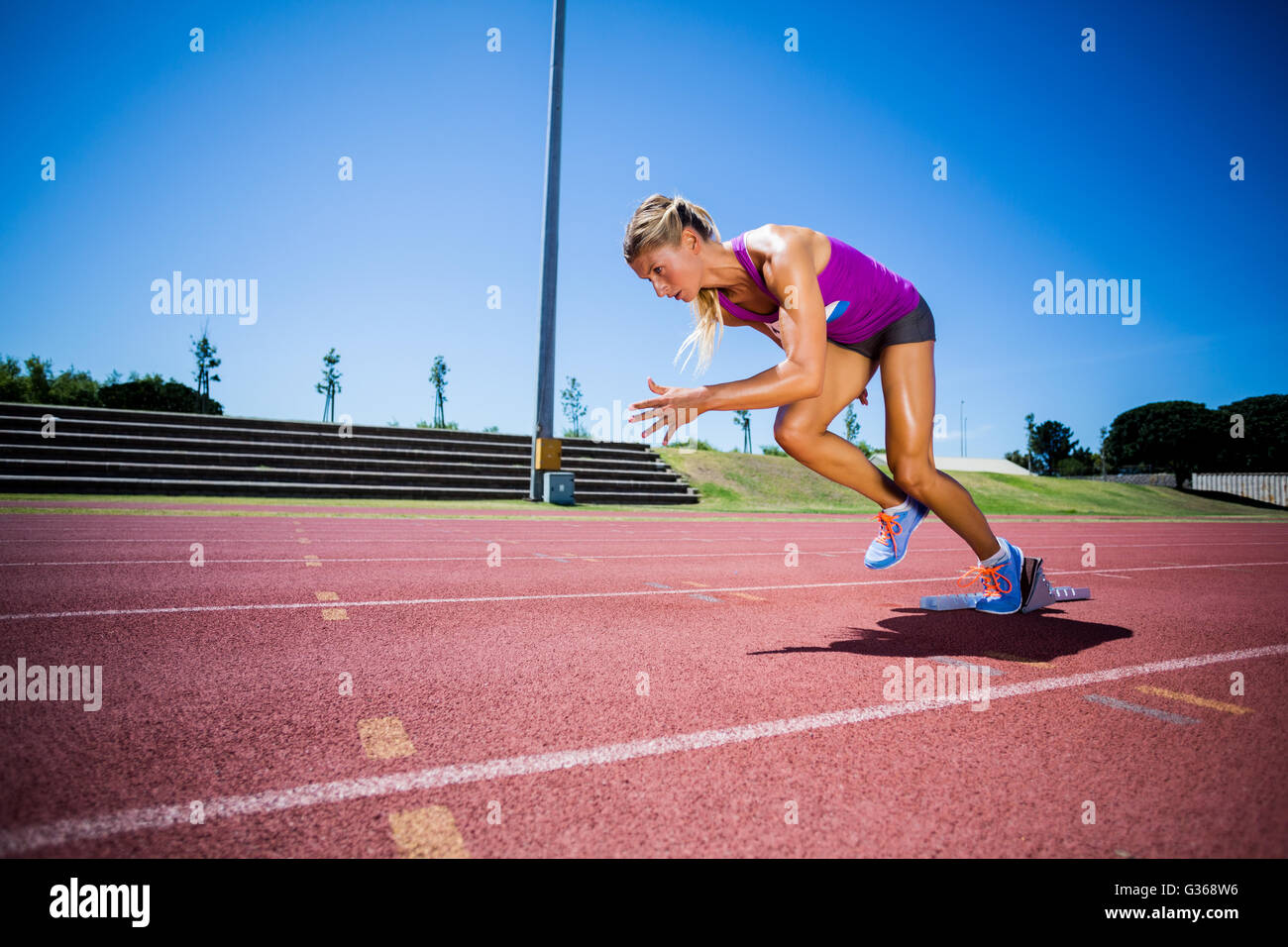 Athlète féminin exécutant sur la piste de course Banque D'Images Athlète féminin exécutant sur la piste de course Banque D'Images