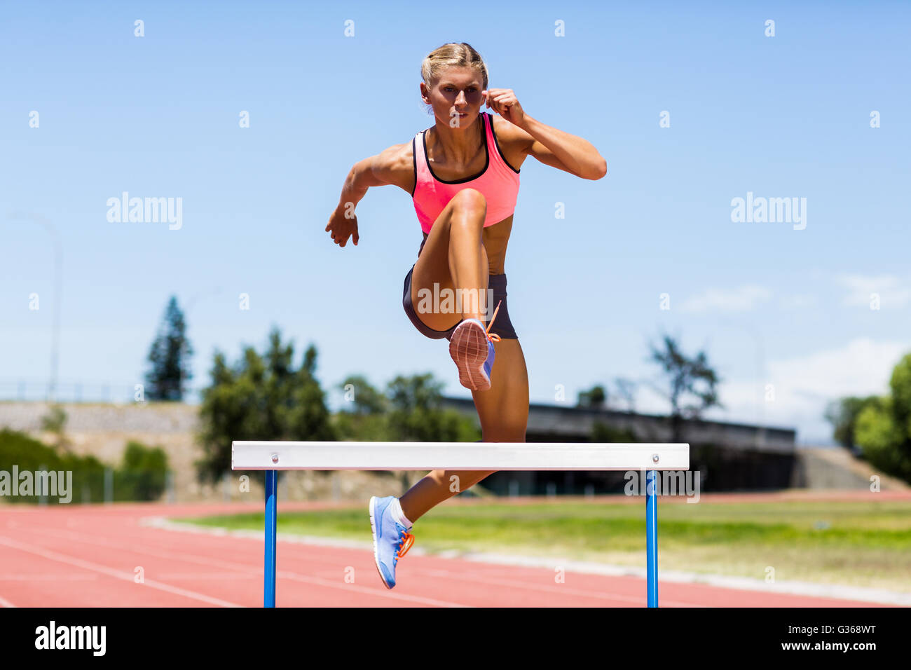 Saut à l'athlète féminine au-dessus de l'obstacle Banque D'Images Saut à l'athlète féminine au-dessus de l'obstacle Banque D'Images