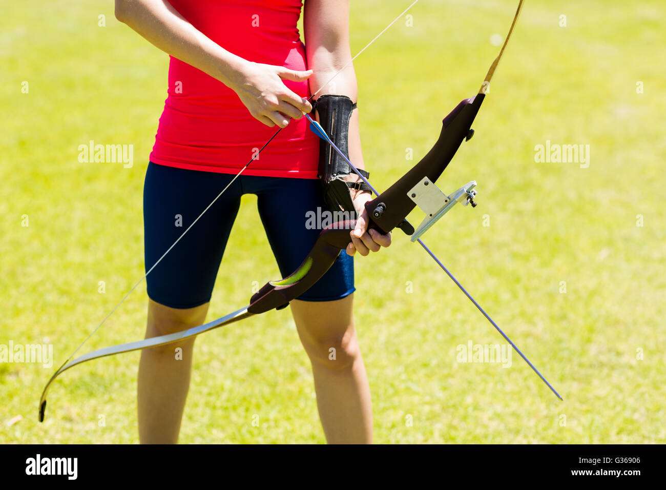 La mi-section de femmes athlètes practicing archery Banque D'Images La mi-section de femmes athlètes practicing archery Banque D'Images