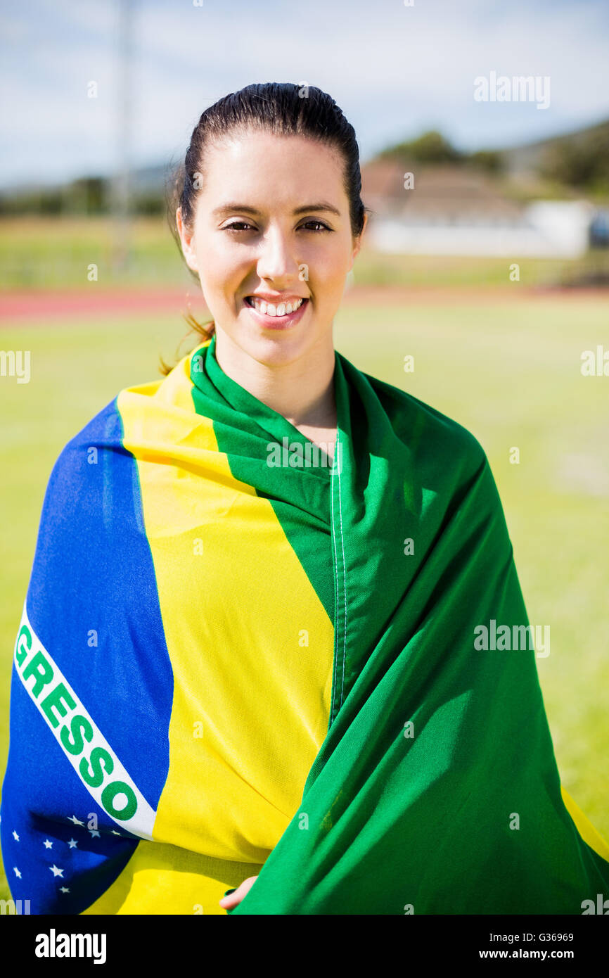 Athlète féminin enveloppé dans un drapeau brésilien Banque D'Images