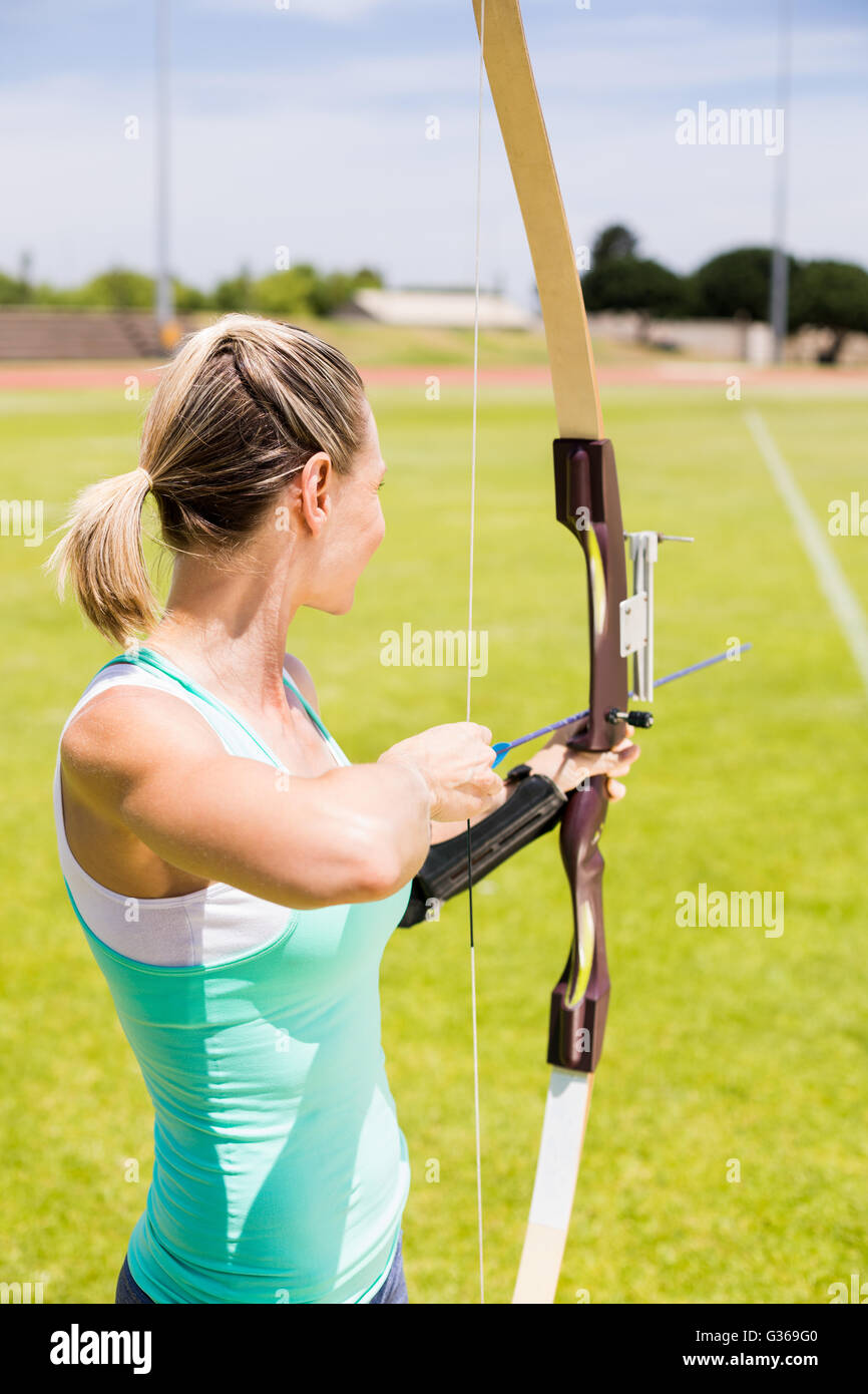 Athlète féminine heureuse practicing archery Banque D'Images Athlète féminine heureuse practicing archery Banque D'Images