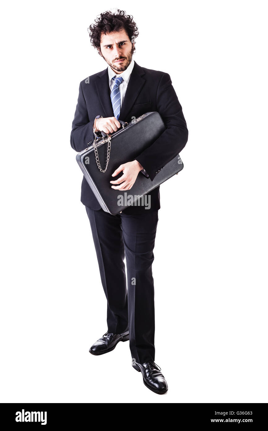 Businessman portant un costume avec une valise sécurisée attaché avec des menottes isolé sur fond blanc Banque D'Images