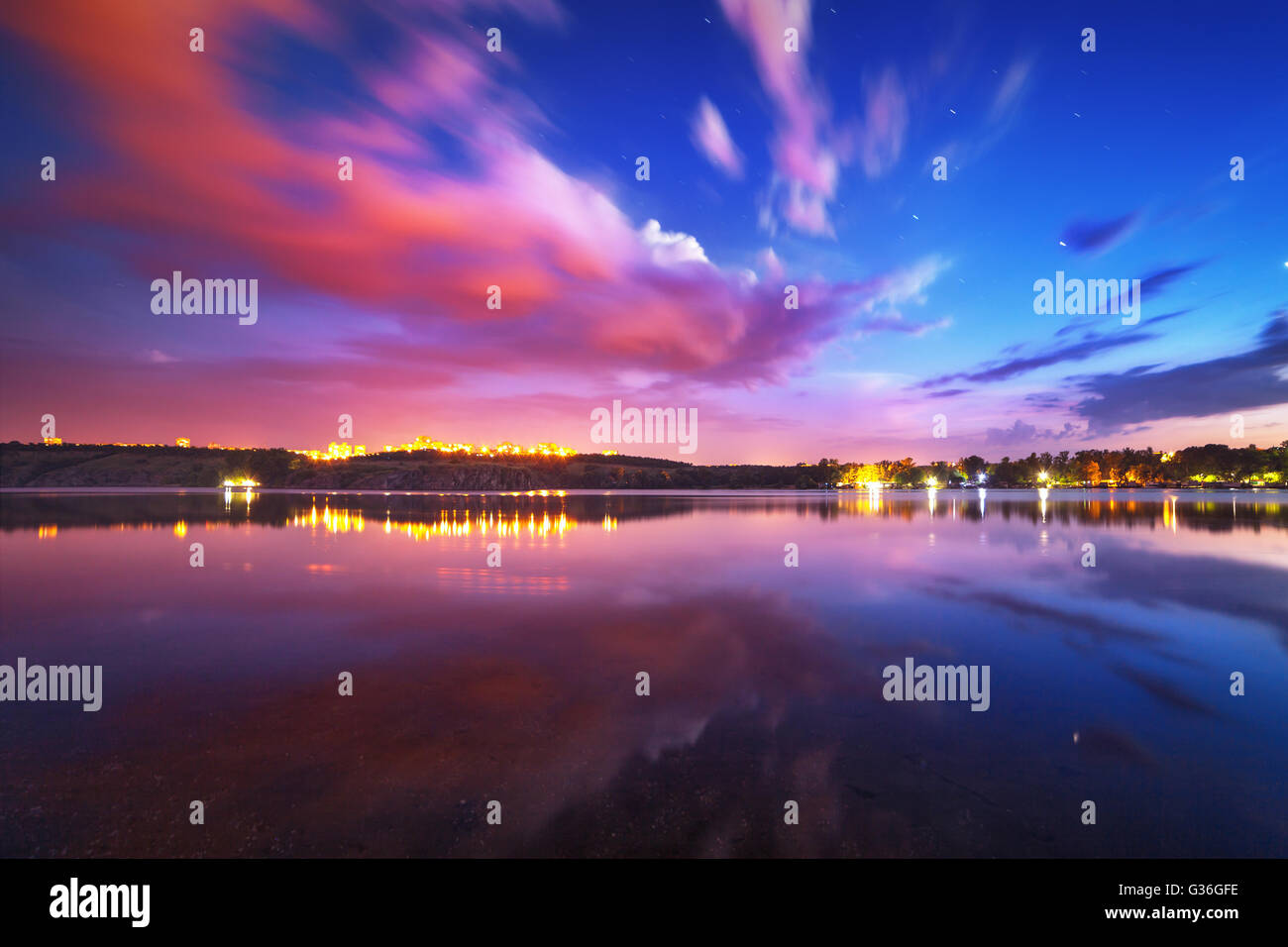 Paysage de nuit sur le lac avec ciel bleu et nuages en mouvement reflète dans l'eau. Nature fond Banque D'Images