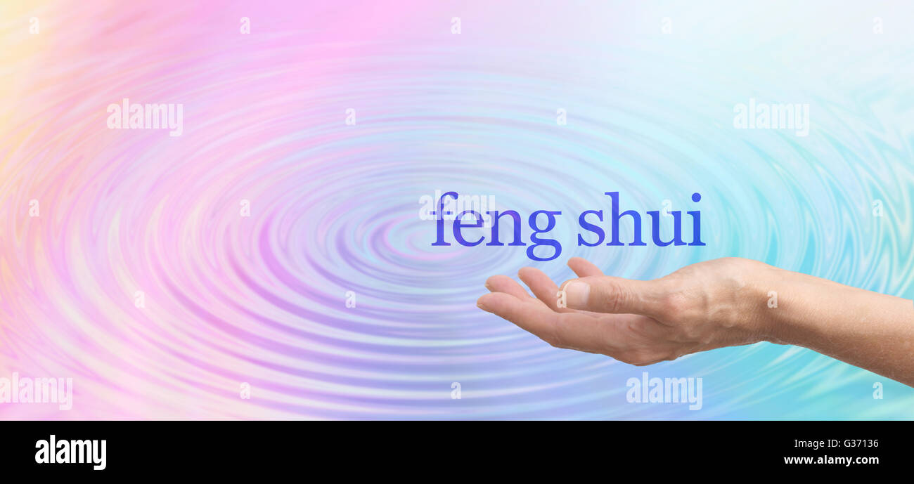 Palm main de femme avec le Feng Shui mots flottant au-dessus sur un large arc-en-ciel pastel effet d'arrière-plan d'eau Banque D'Images
