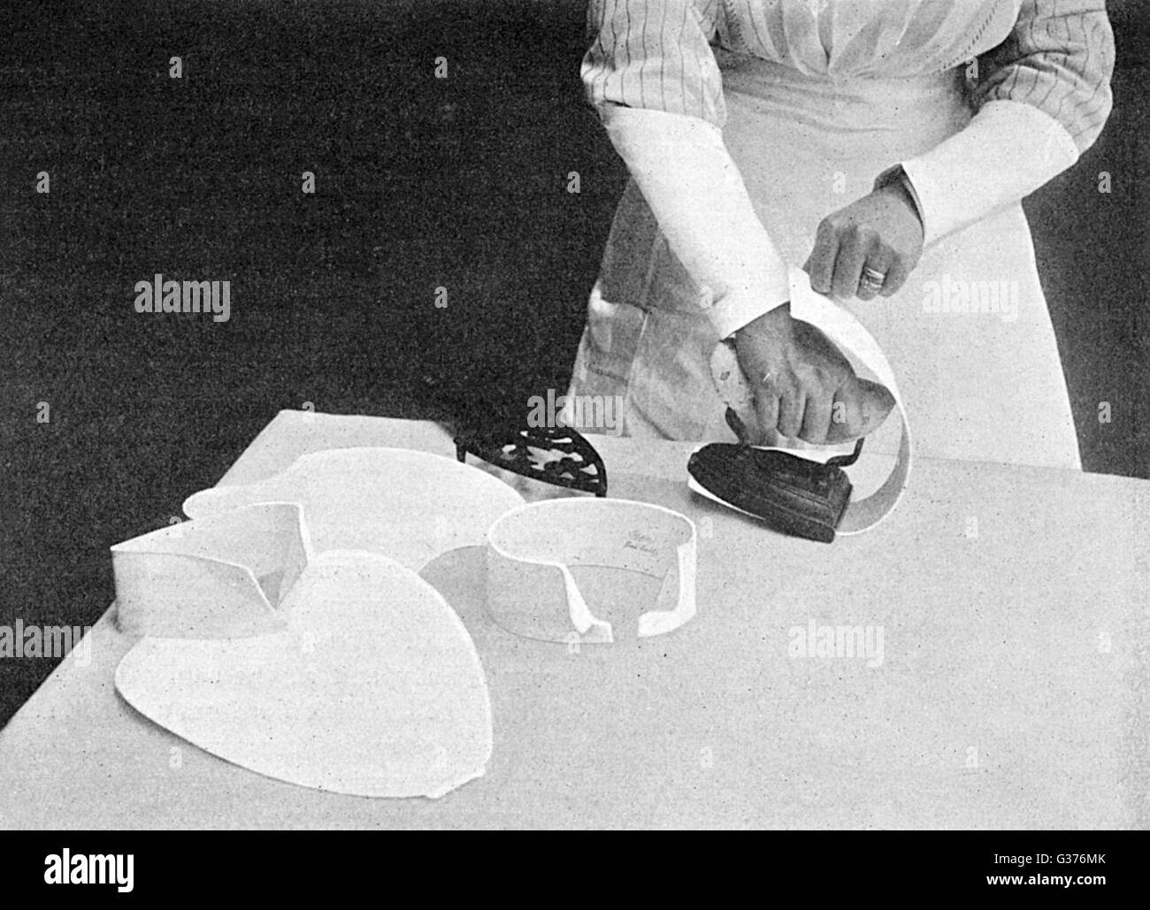 Photographie démontrant la technique pour le repassage bib et cols en 1911. Date : 1911 Banque D'Images