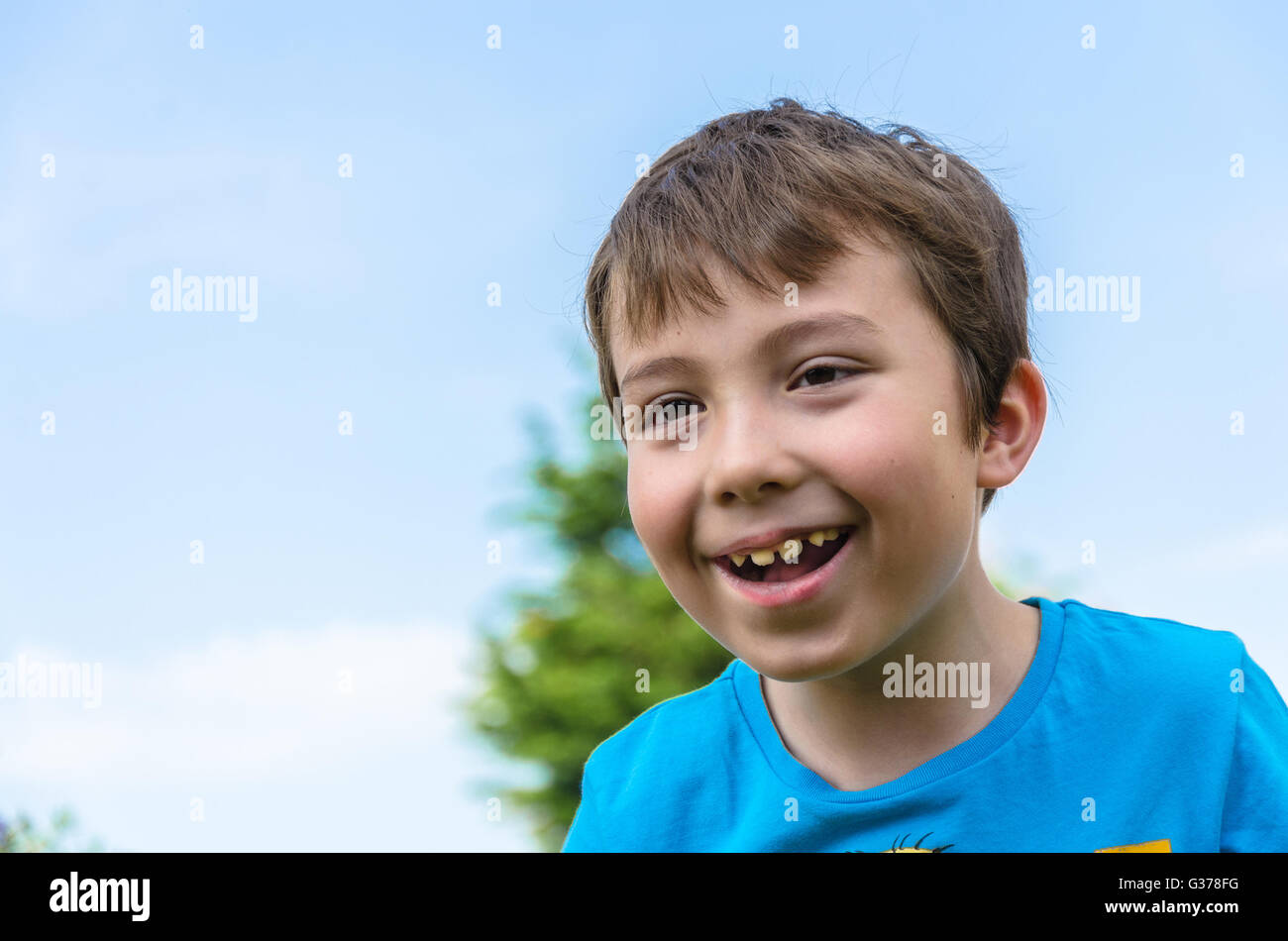 Un portrait d'un jeune garçon contre un ciel bleu. Banque D'Images