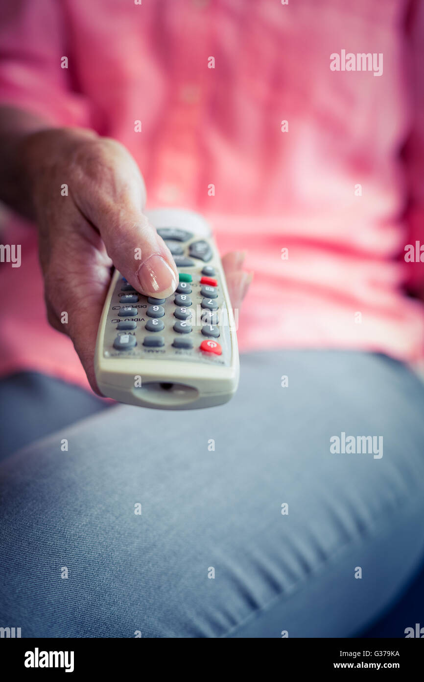 Senior woman changing tv channel Banque D'Images