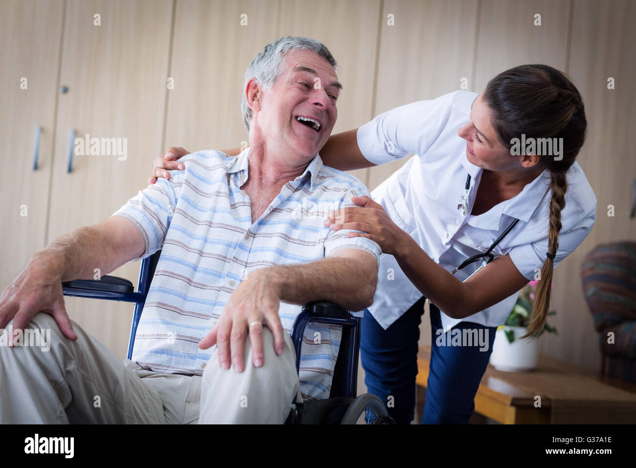 Happy senior man et l'interaction médecin dans la salle de séjour Banque D'Images
