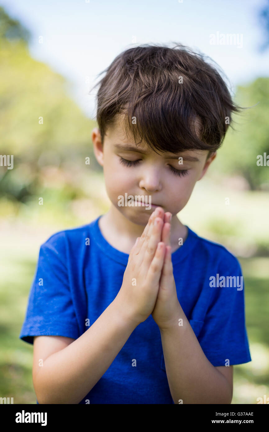 Garçon en prière avec les yeux fermés Banque D'Images