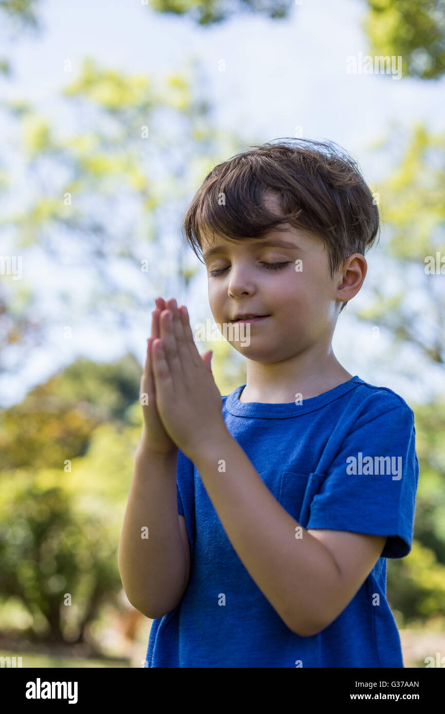 Garçon en prière avec les yeux fermés Banque D'Images