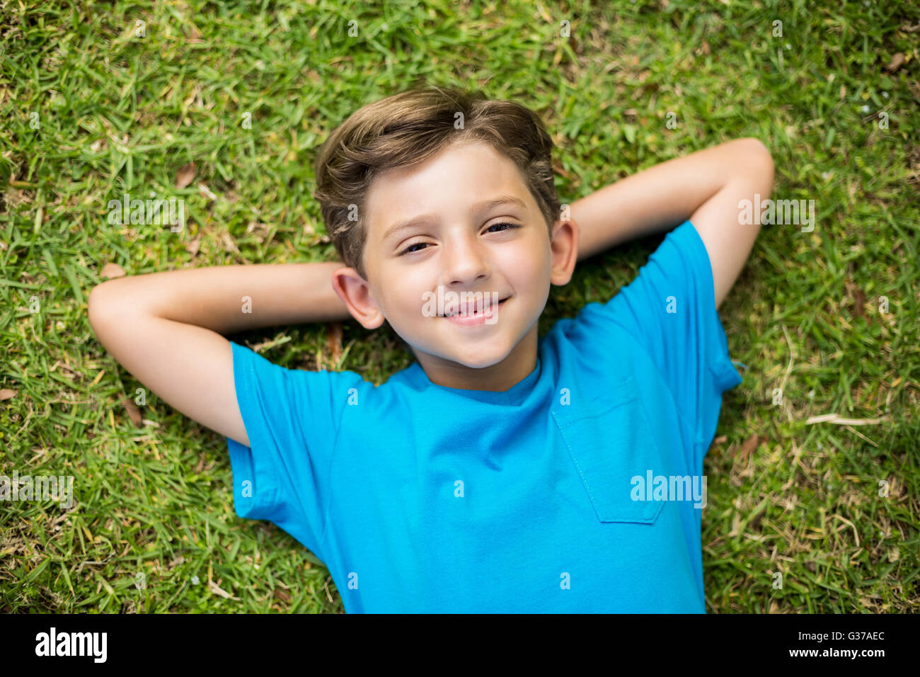 Young boy lying on grass Banque D'Images