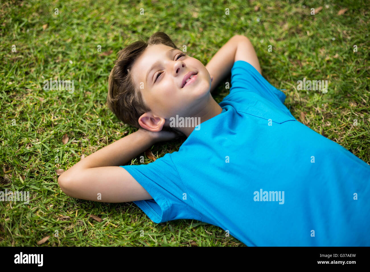 Young boy lying on grass Banque D'Images