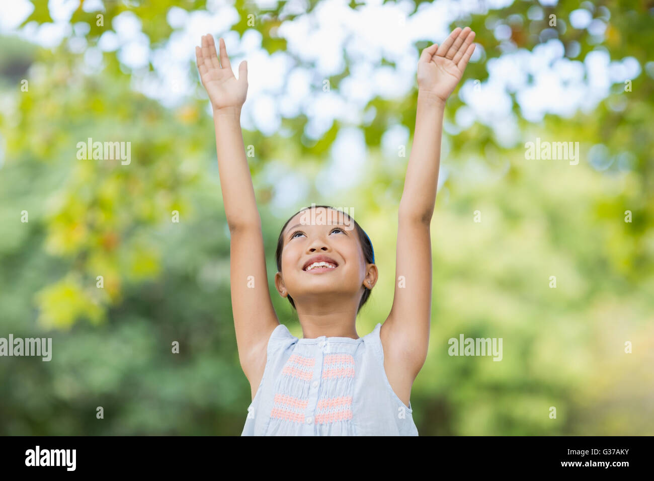 Smiling Girl standing with arms raised Banque D'Images