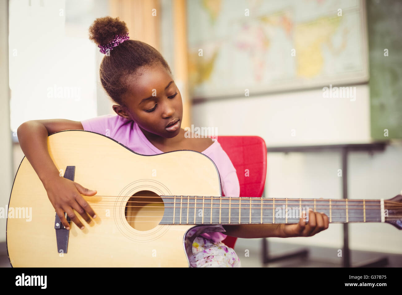 Lycéenne qui joue de la guitare en classe Banque D'Images