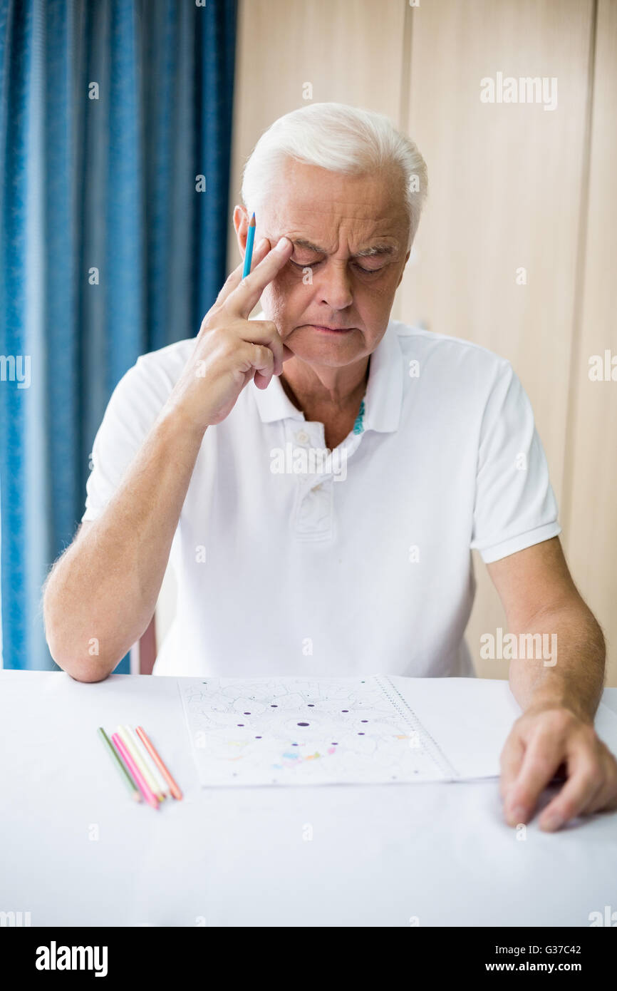 Man en utilisant un livre de coloriage Banque D'Images