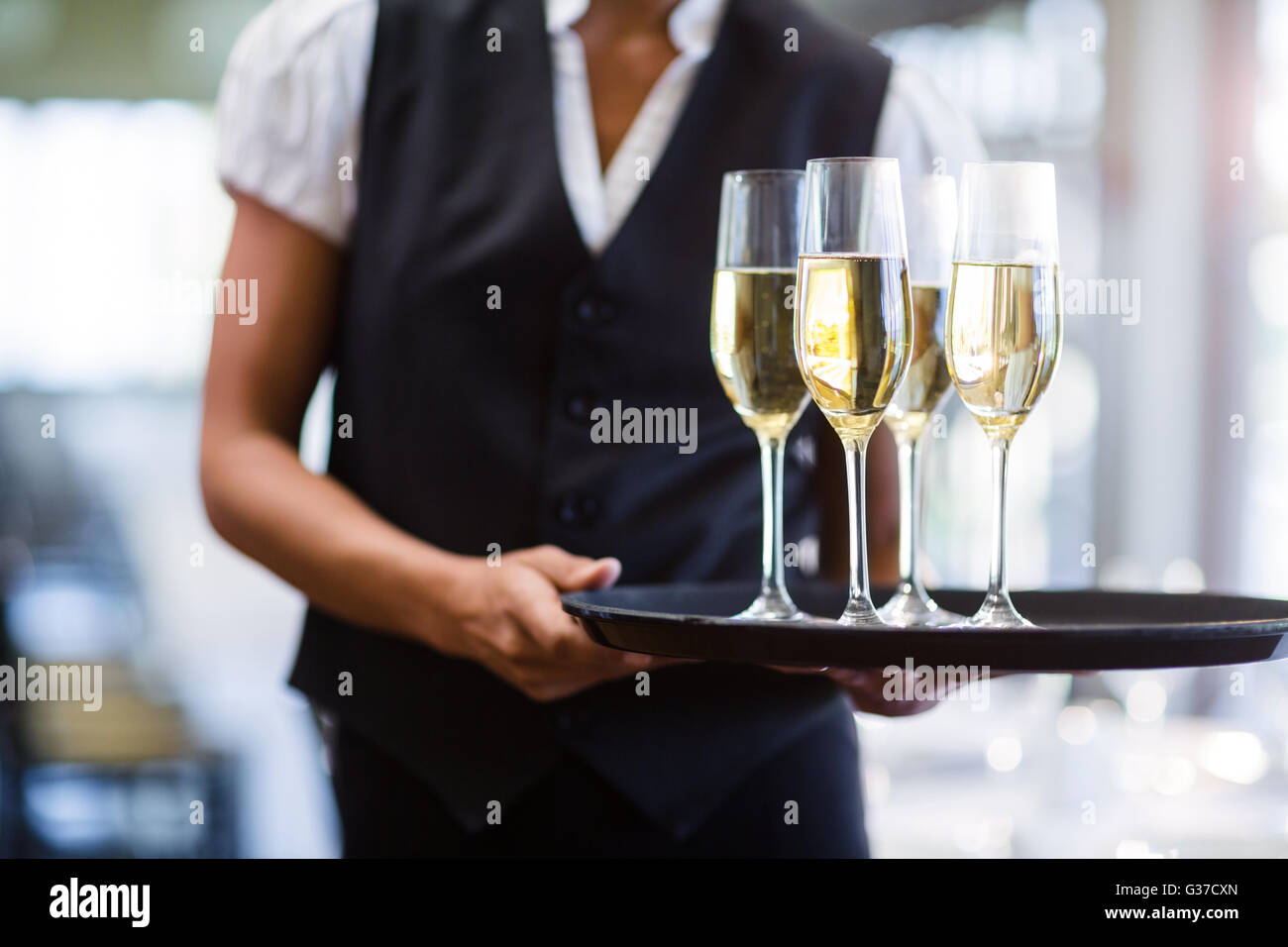 Waitress holding champagne flutesB avec plateau de service Banque D'Images Waitress holding champagne flutesB avec plateau de service Banque D'Images
