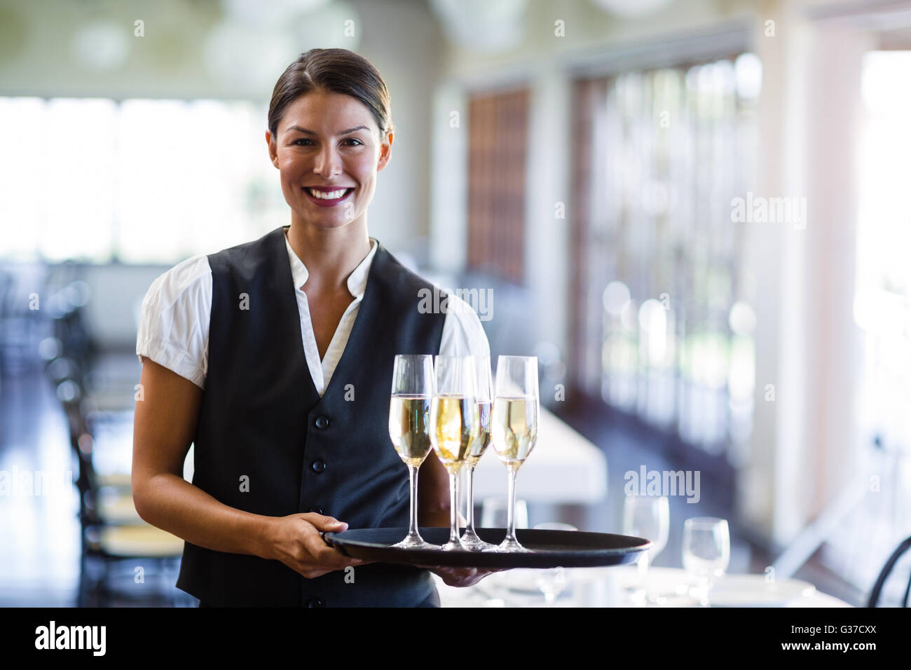 Portrait of waitress holding champagne flutesB avec plateau de service Banque D'Images Portrait of waitress holding champagne flutesB avec plateau de service Banque D'Images