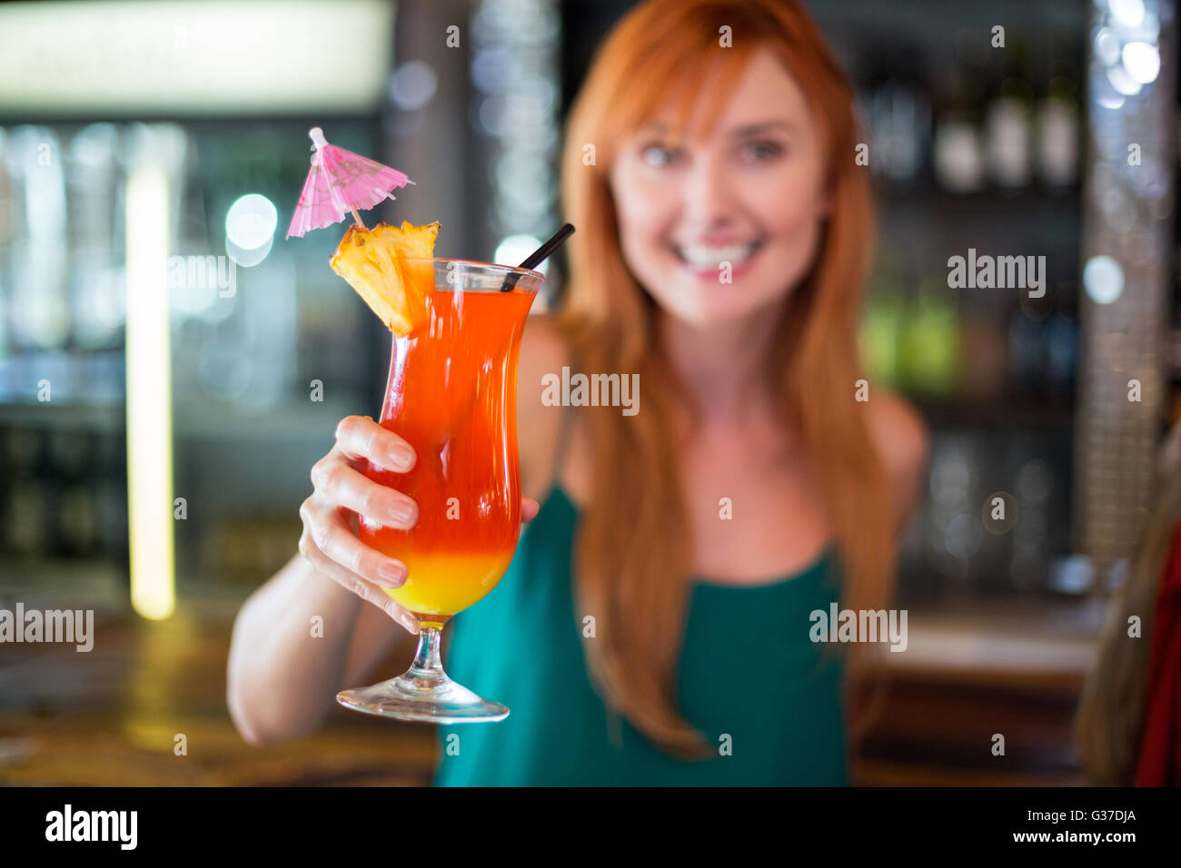 Portrait of happy woman holding a cocktail glass au comptoir du bar Banque D'Images