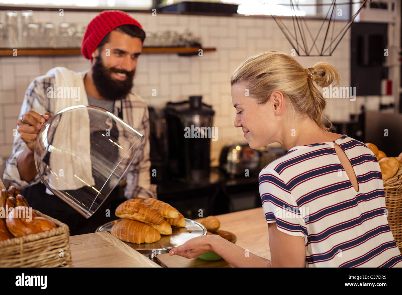 Vendeur présentant des croissants à un client Banque D'Images