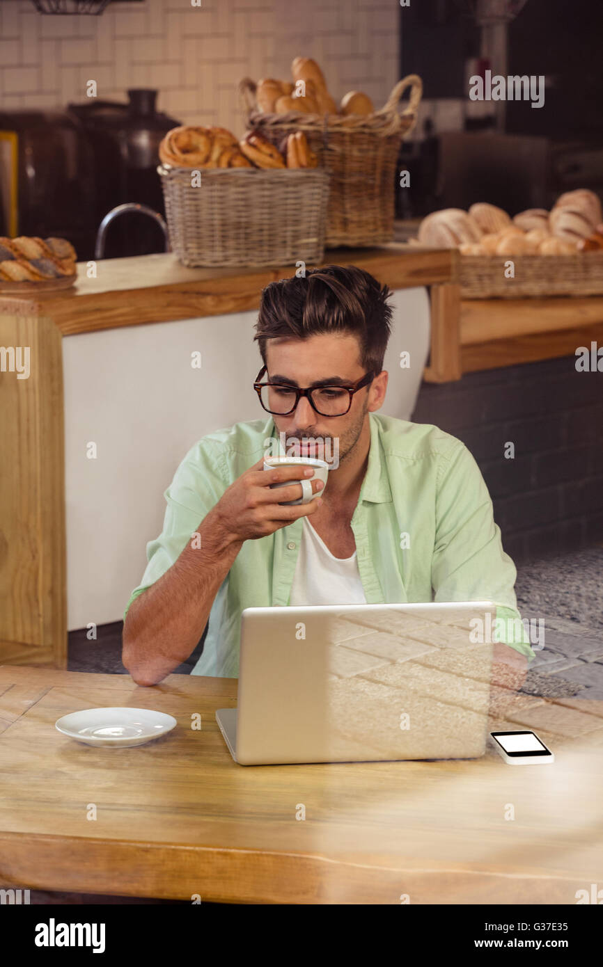 À l'aide d'un ordinateur portable branché boire du café Banque D'Images