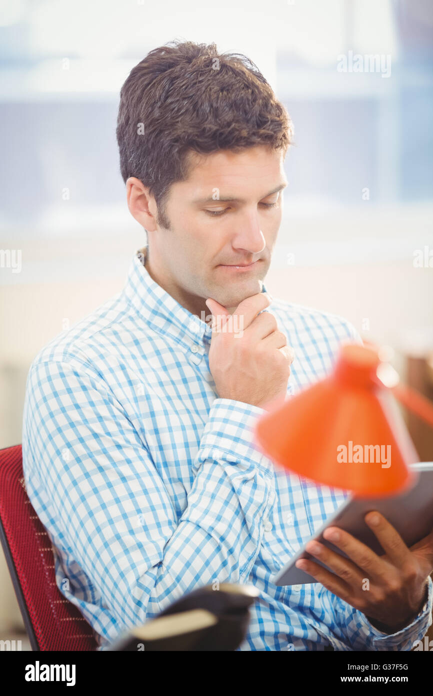 Thoughtful businessman en utilisant sa tablette Banque D'Images