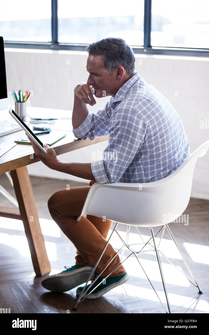 Vue latérale du businessman reflétant et en utilisant un ordinateur tablette Banque D'Images