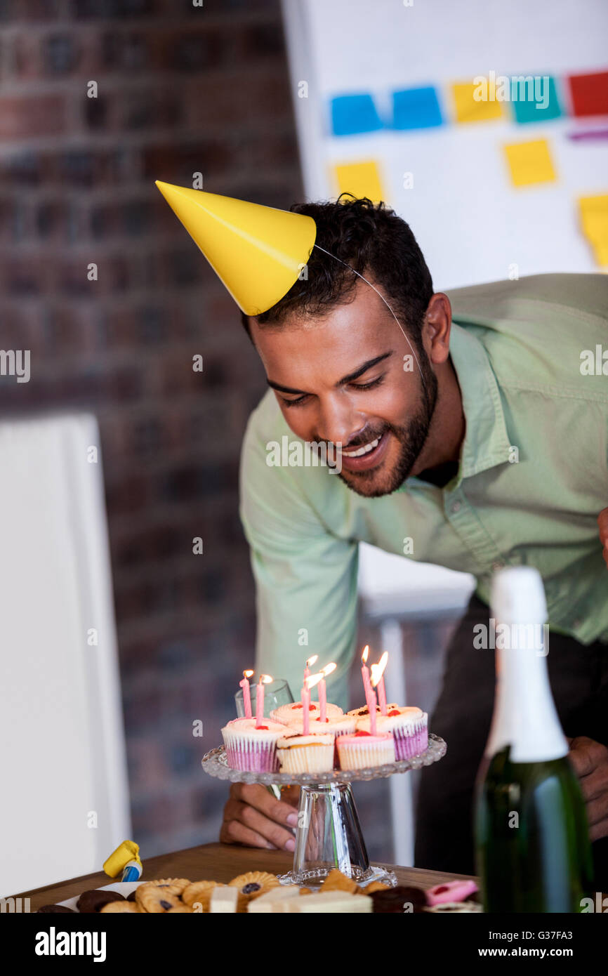 Portrait of businessman souffler les bougies pour son anniversaire Banque D'Images