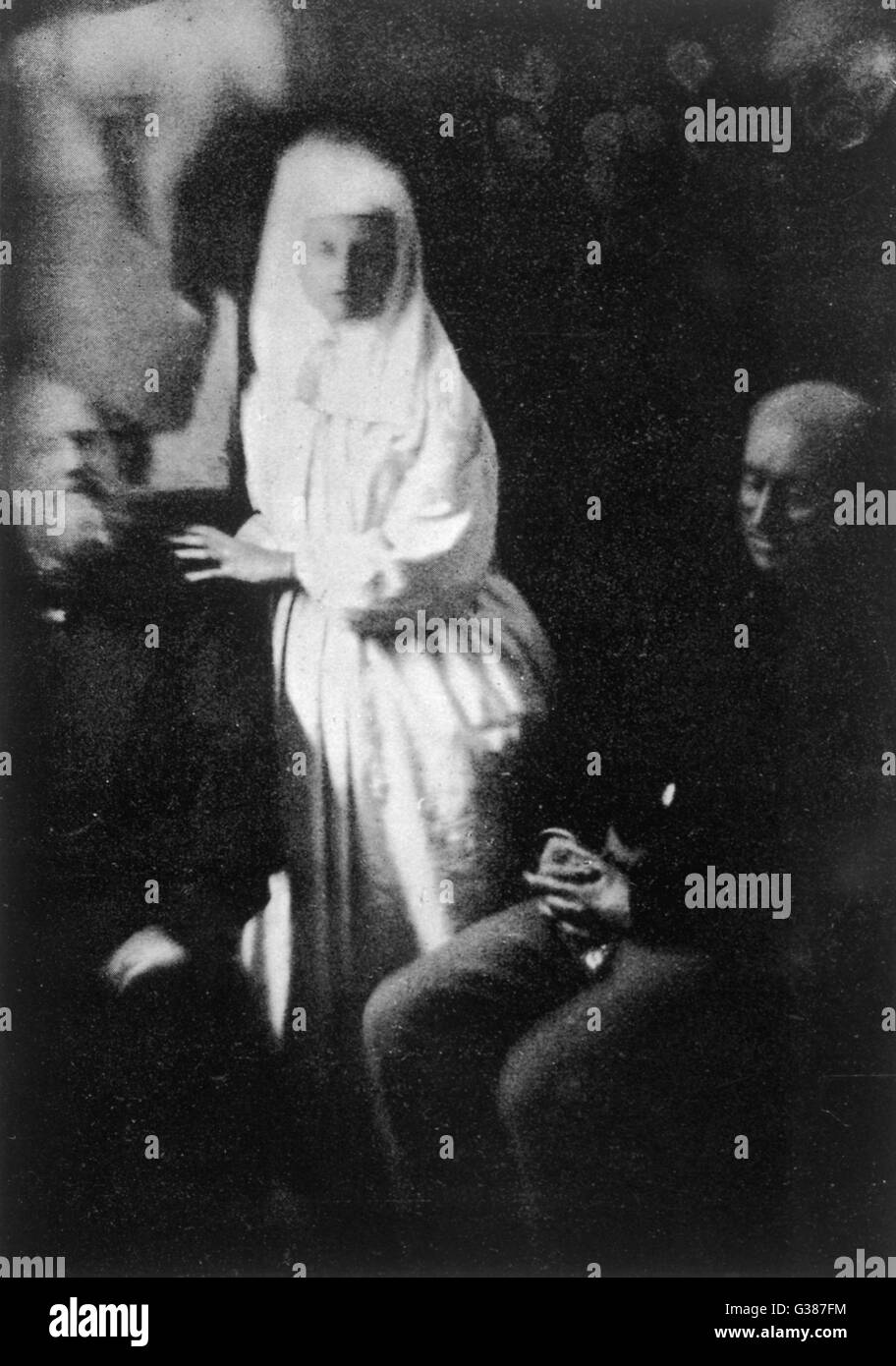 'Katie King' touche un sitter, tandis qu'un autre semble indifférent à sa présence, à la maison de Sir William Crookes Date : 1874 Banque D'Images