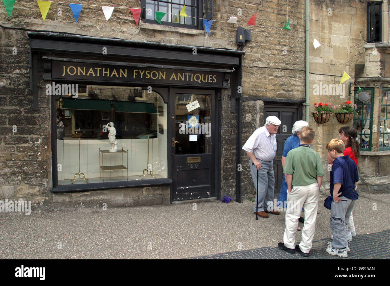 Des Cotswolds. Générations en conversation, vieux et jeunes, à l'extérieur de Jonathan Fyson antiquités dans la ville de Burford. Banque D'Images