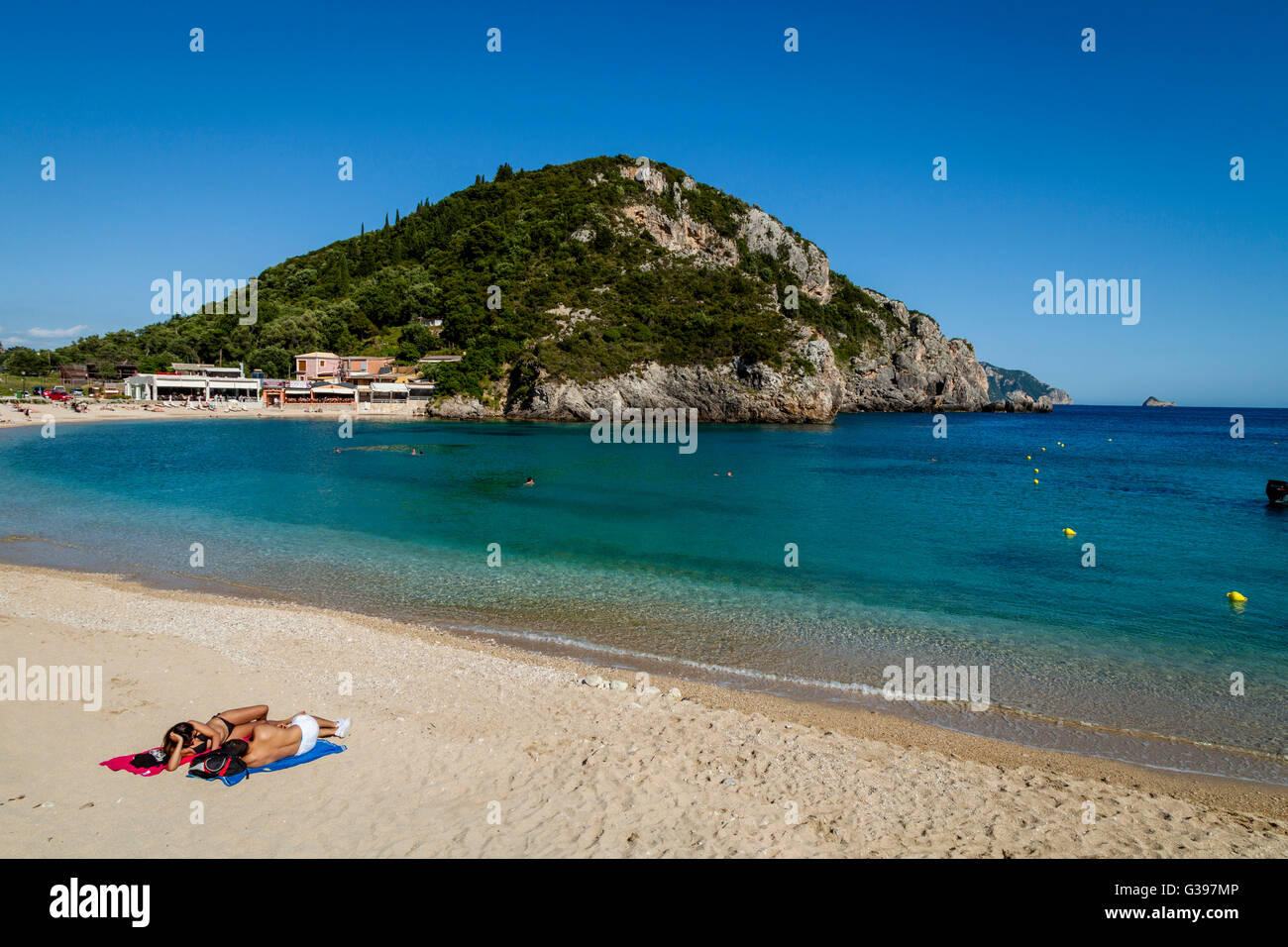 Un jeune couple en train de bronzer sur la plage de Paleokastritsa, Corfou (île), Grèce Banque D'Images