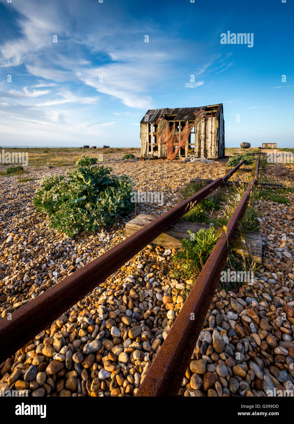 Une vieille cabane de pêche et de pistes sur la plage de galets de Dungeness, Kent. Banque D'Images