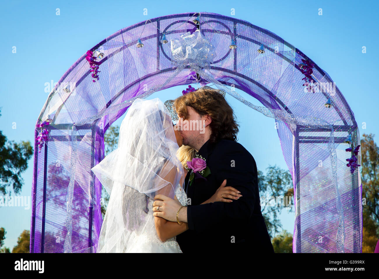 Un couple partage leur premier baiser à la modifier au cours de leur cérémonie de mariage. Banque D'Images