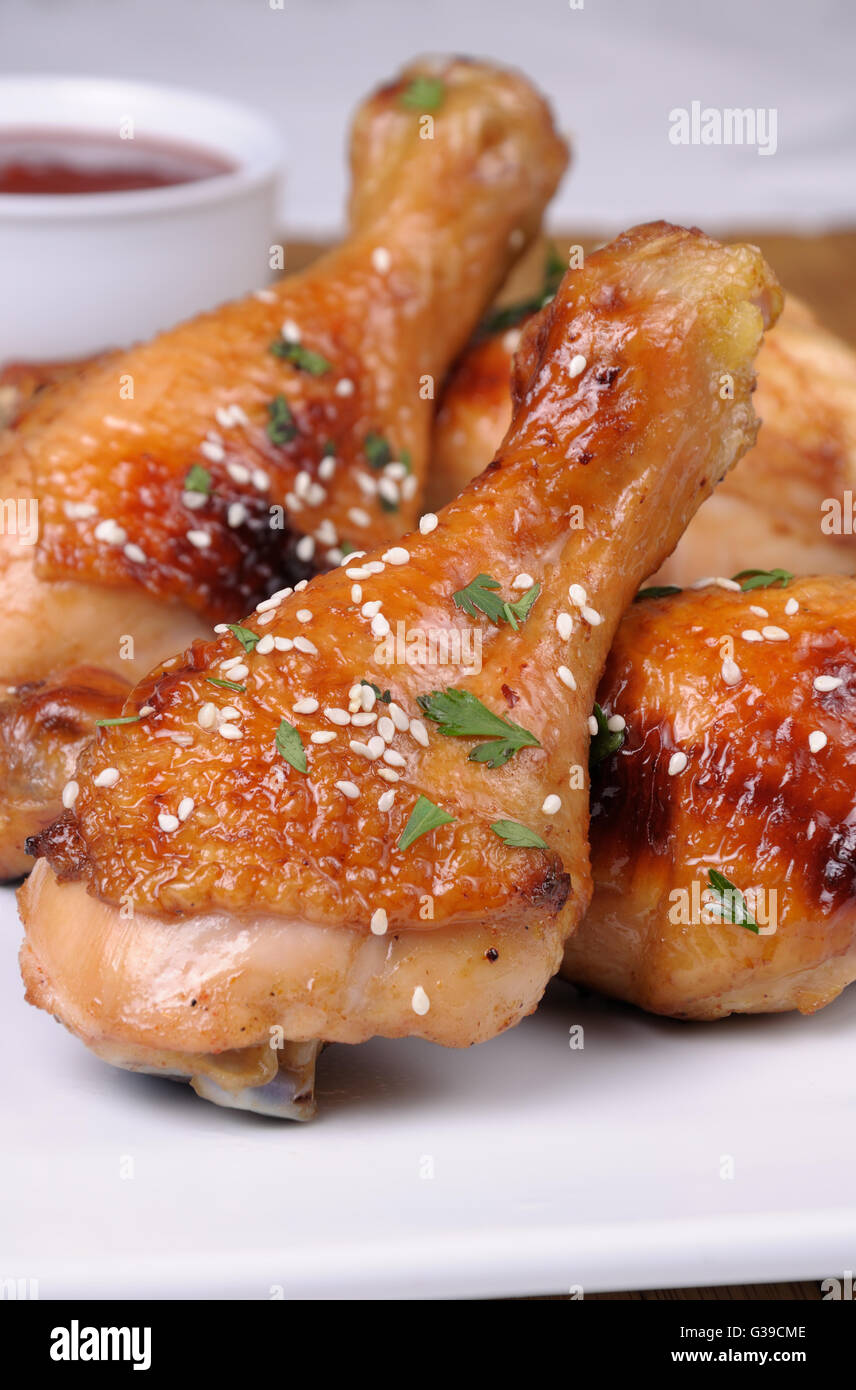 Cuisse de poulet frit avec des graines de sésame dans une assiette et la sauce libre Banque D'Images