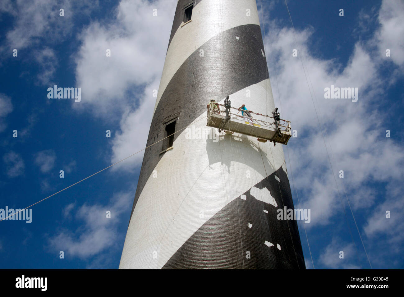 Travailleurs s'appliquent une deuxième de quatre couches de peinture sur la spirale blanche bande sur Cape Hatteras phare de Cape Hatteras National Seashore 1er mai 2014 à Buxton, Caroline du Nord. Banque D'Images