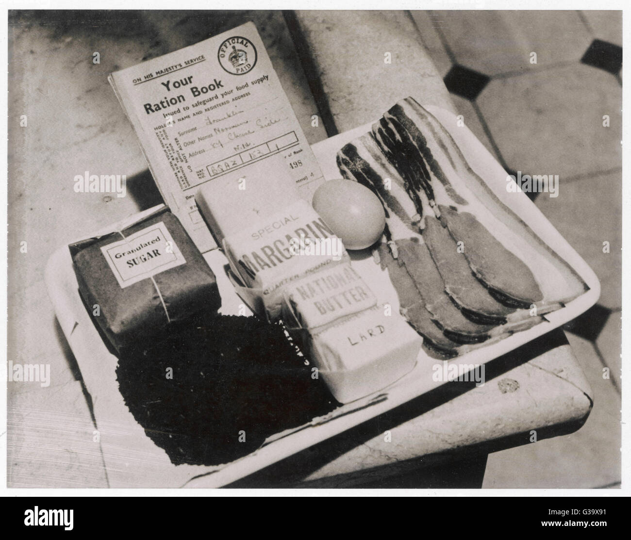 Une ration d'adresses avec des rations pour une semaine, comprenant quatre tranches de bacon, un œuf et une quantité de sucre et de gras Date : Seconde Guerre mondiale Banque D'Images