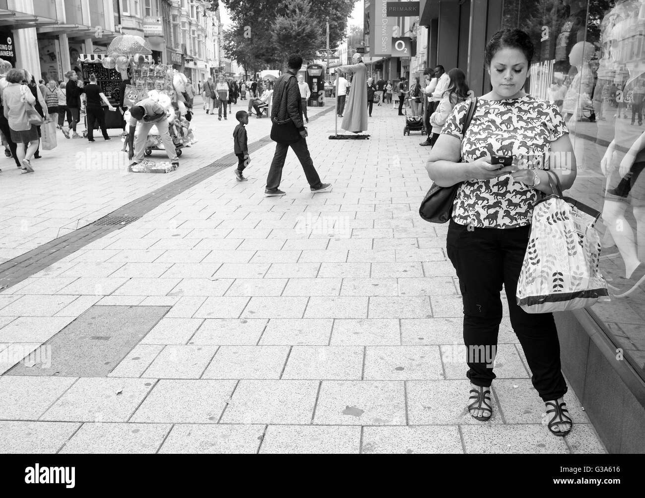 Juin 2016 - Jeune femme avec son téléphone mobile dans le centre de Cardiff. Banque D'Images