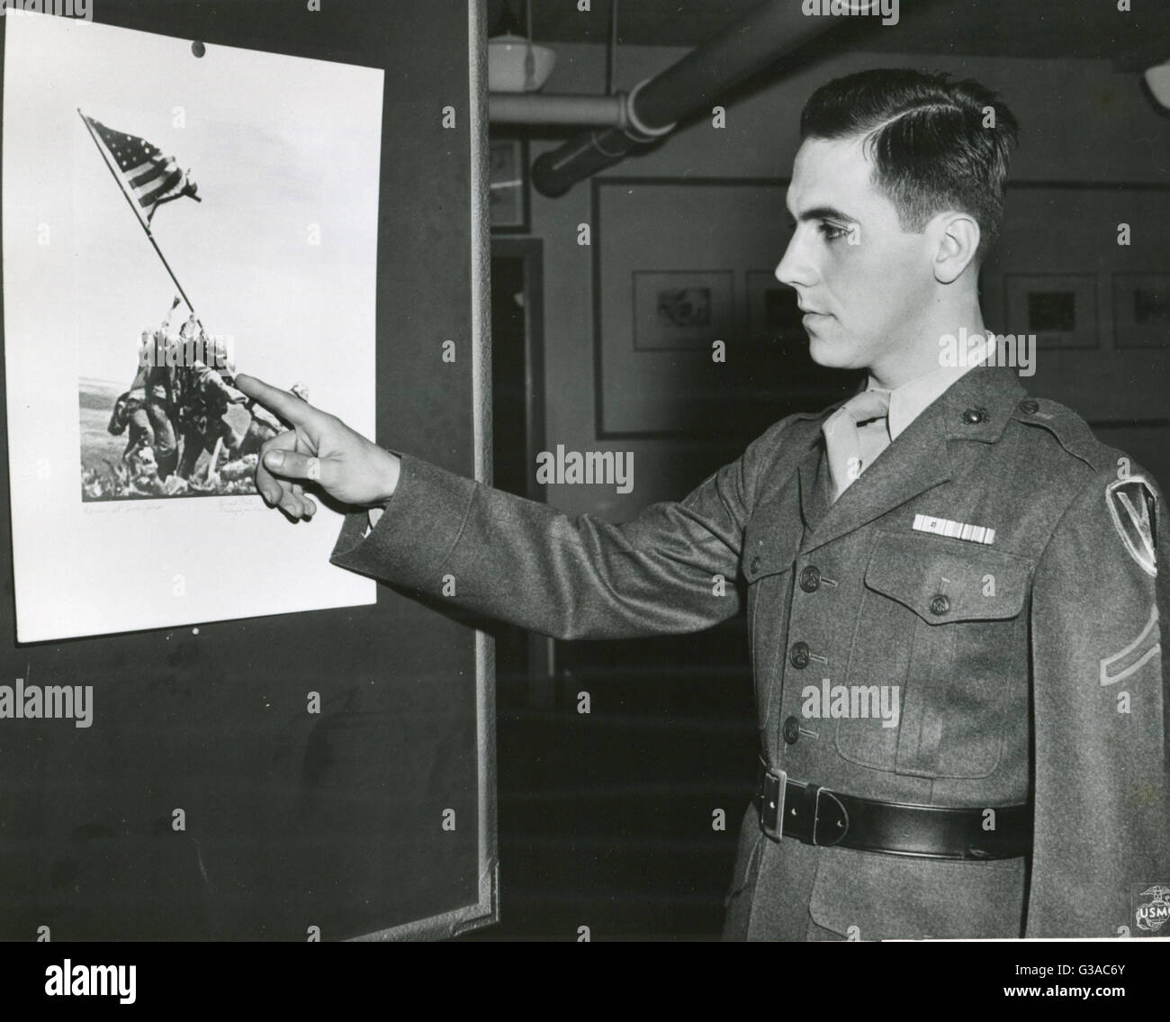 Le Soldat de première classe Marine Rene Gagnon souligne la figure de lui-même dans les photos de Marines sensibilisation ancienne gloire au sommet du mont Suribachi Iwo Jima. La photo sera utilisé pour la nouvelle 7ème emprunt de guerre de l'affiche. Banque D'Images