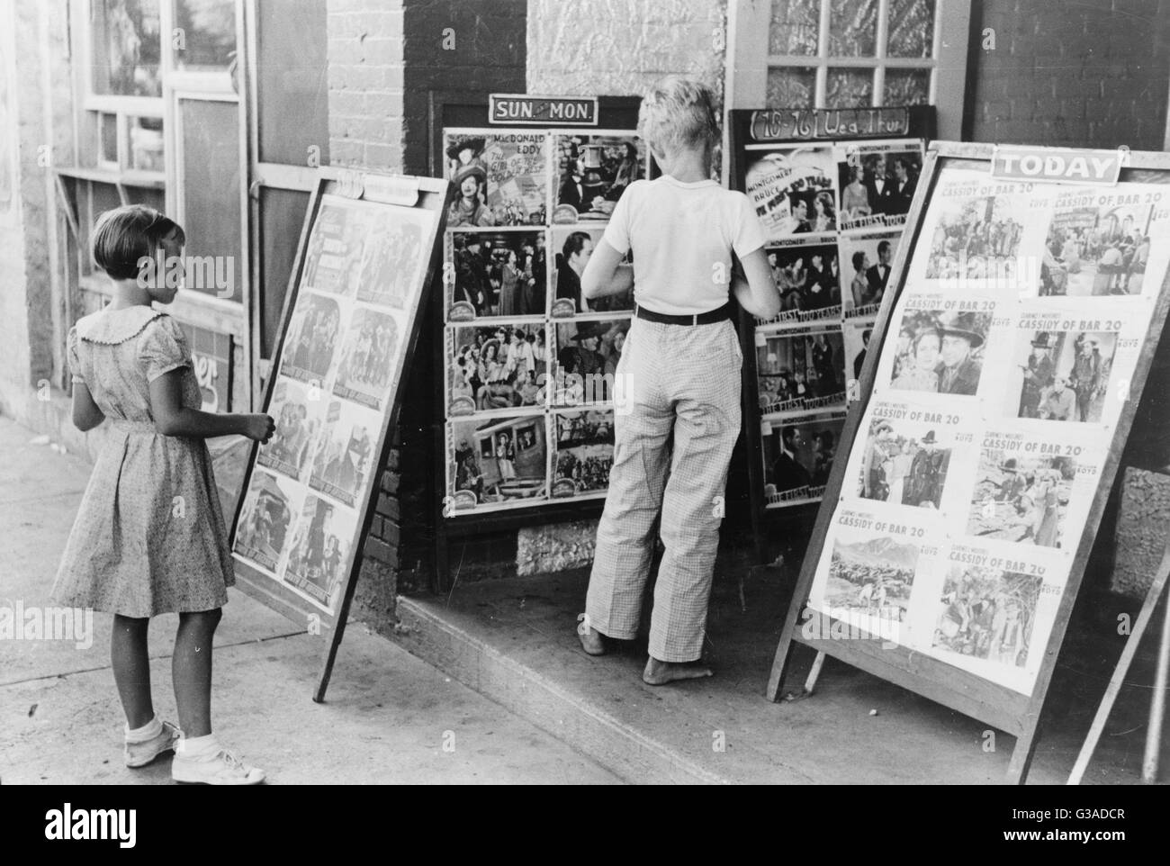 Enfants regardant des affiches devant le film, samedi, Ste Banque D'Images
