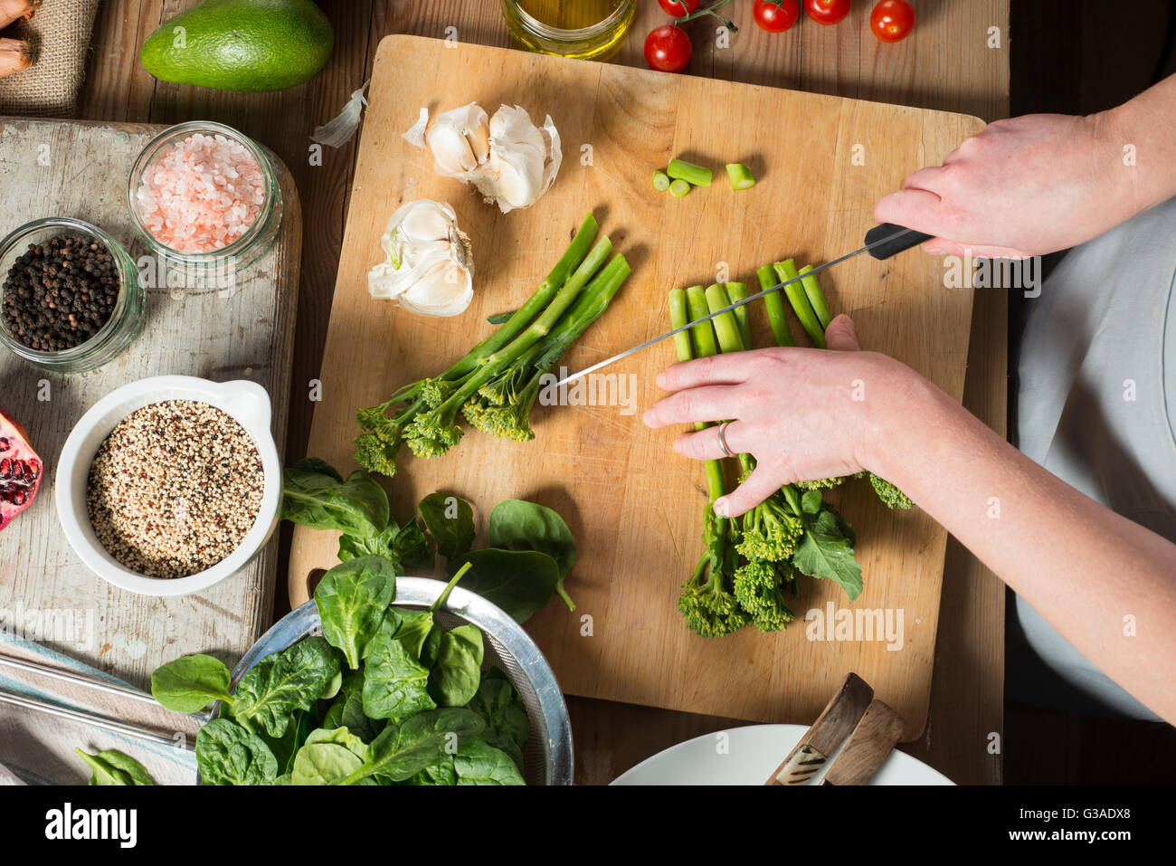 Frais généraux de mains couper le brocoli sur bois avec d'autres ingrédients aux côtés Banque D'Images