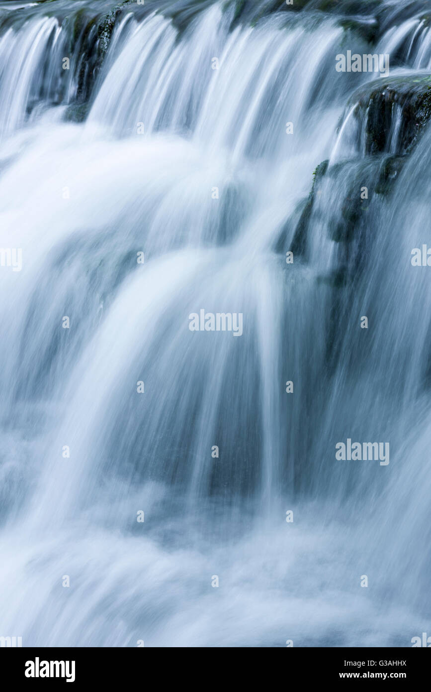 Au cours d'une cascade d'eau avec effet de flou. Tumbling Weir sur la rivière Yeo à Wrington, North Somerset, Angleterre. Banque D'Images