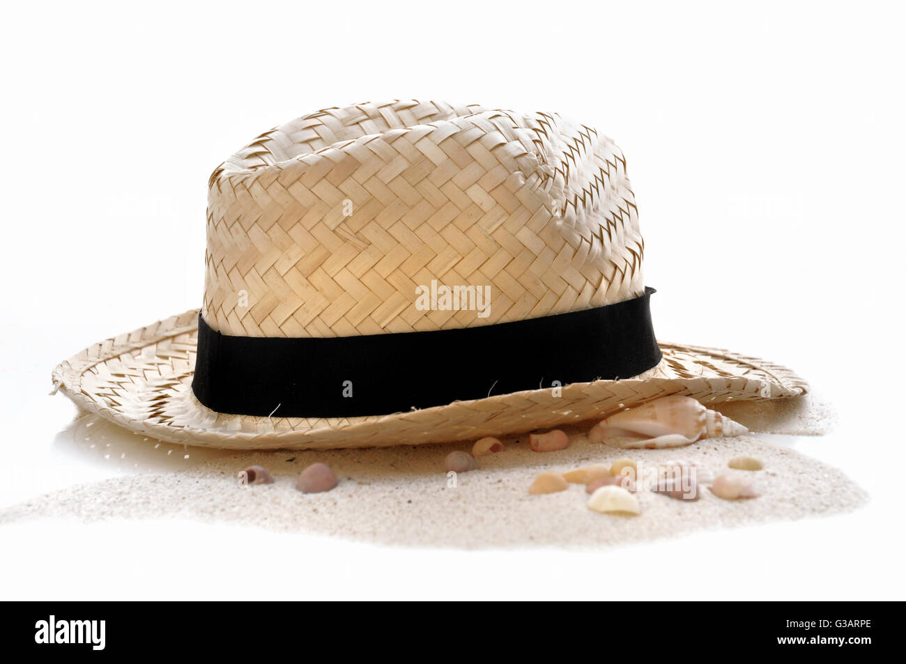 Chapeau de paille dans le sable sur fond blanc Banque D'Images