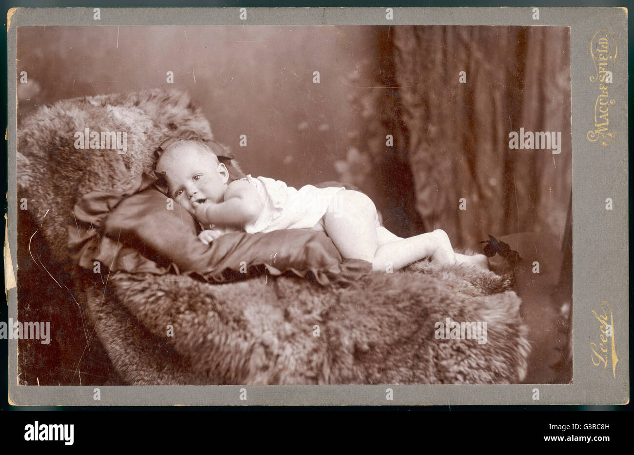 BÉBÉ SUR UN TAPIS DE FOURRURE FIN 19C Banque D'Images