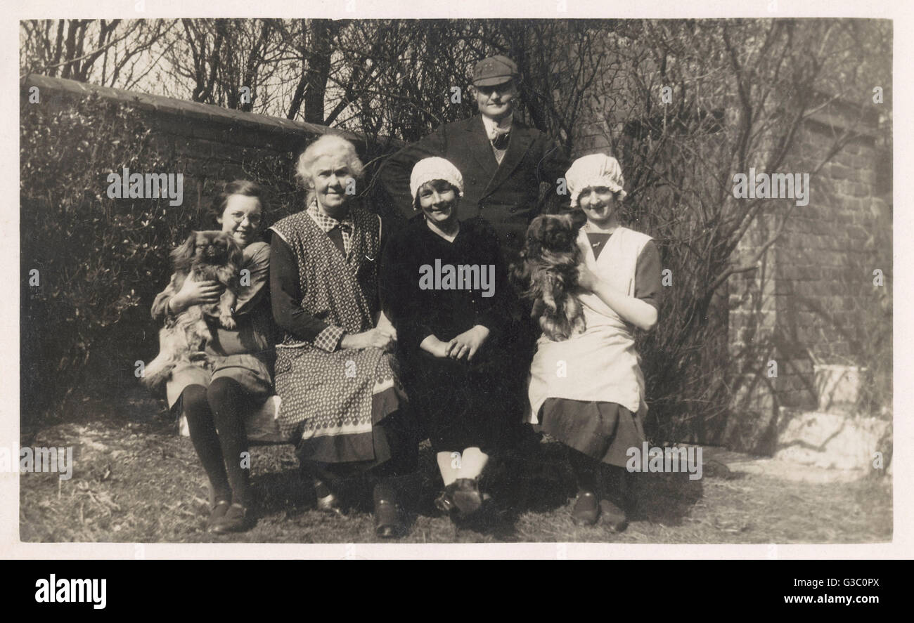 Groupe familial avec deux chiens dans un jardin Banque D'Images