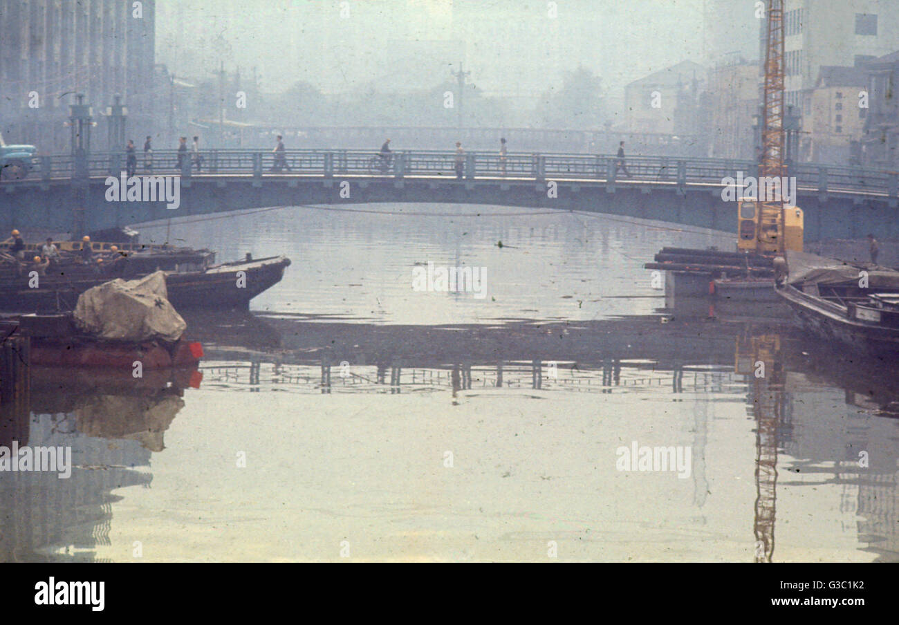 Les personnes qui traversent un pont sur la rivière, Tokyo, Japon. Date : vers 1990 Banque D'Images