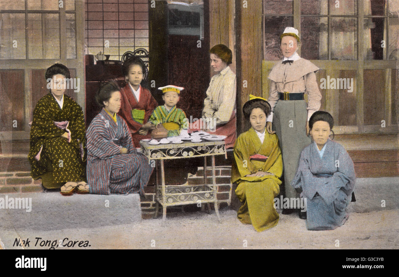 La femme coréenne et occidentale prenant le thé à l'extérieur de la Maison de Mission Tong Nak, Séoul, Corée. Les femmes occidentales sont des enseignants de la société missionnaire pour la propagation de l'Évangile (SPG). Date : vers 1910 Banque D'Images